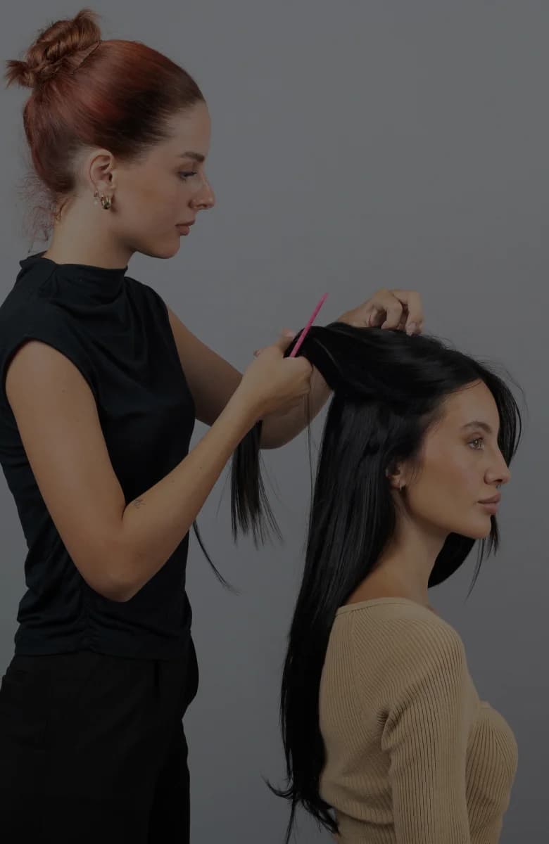 Professional stylist applying hair extensions